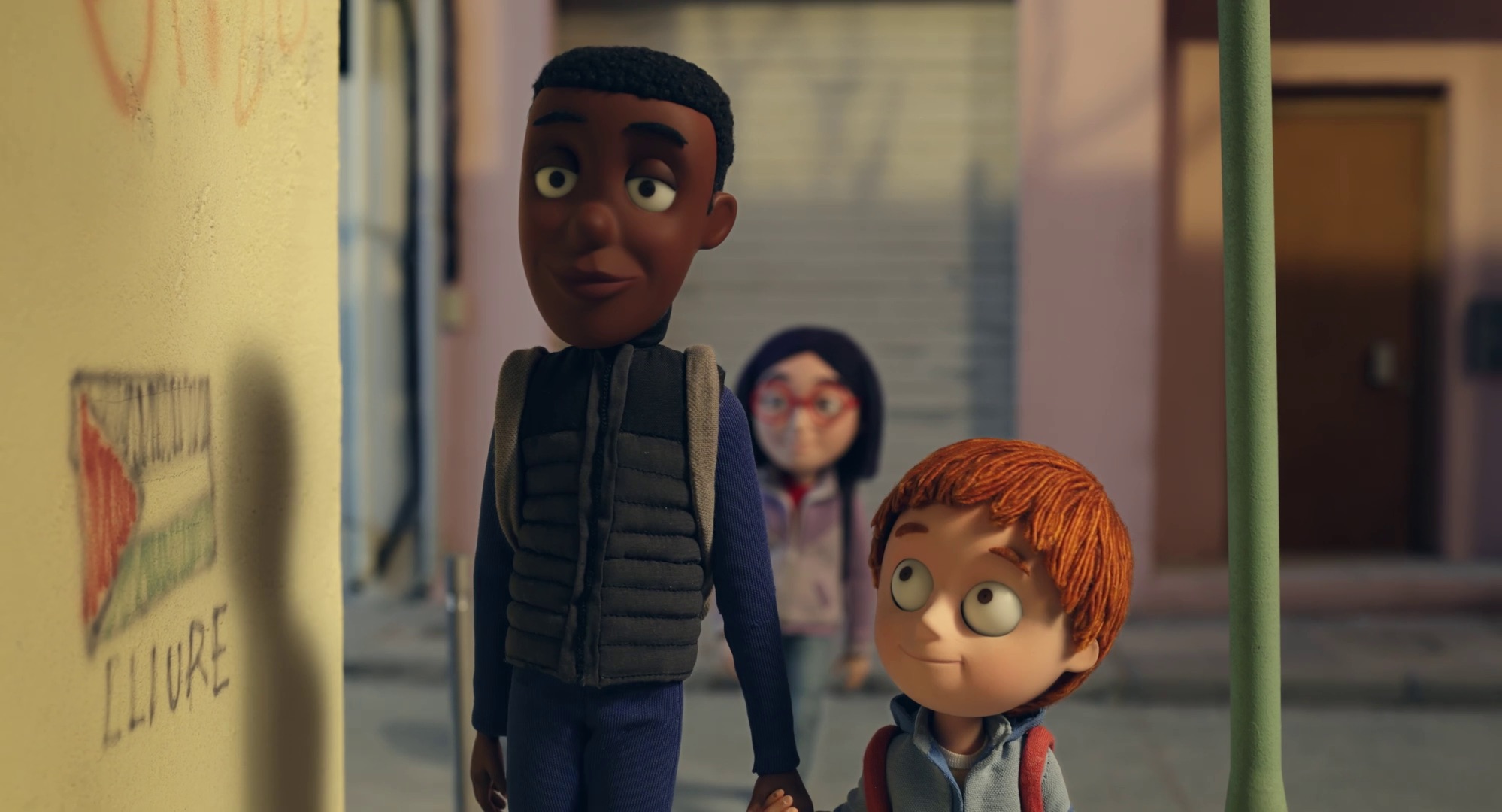 Lamine Tim et Olivia marchent devant un tag qui représente le drapeau de la Palestine